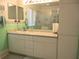 Bathroom vanity featuring a large mirror, cabinets, and cultured marble countertop at 11470 Sw 139Th St, Dunnellon, FL 34432