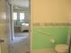 Bathroom view to the bedroom featuring a toilet with safety bar and bedroom access at 11470 Sw 139Th St, Dunnellon, FL 34432