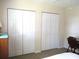 Bedroom featuring a neutral carpet, bi-fold closet doors, and a desk at 11470 Sw 139Th St, Dunnellon, FL 34432