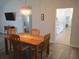 Bright dining room featuring a wooden table with seating for four and a view into the kitchen at 11470 Sw 139Th St, Dunnellon, FL 34432