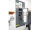 The gray electrical panel on the wall, with a thermometer, circuit breakers, and affixed information at 11470 Sw 139Th St, Dunnellon, FL 34432