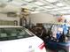 Spacious garage showcasing storage, a workstation, and parking for a car and golf cart at 11470 Sw 139Th St, Dunnellon, FL 34432