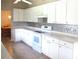 Bright kitchen showcasing white cabinets and appliances, offering ample counter space for cooking at 11470 Sw 139Th St, Dunnellon, FL 34432