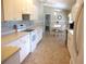 Bright kitchen with white cabinets and appliances, connected to the dining area, with tile flooring at 11470 Sw 139Th St, Dunnellon, FL 34432