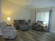 Cozy living room featuring wood floors, comfortable seating, and a ceiling fan at 11470 Sw 139Th St, Dunnellon, FL 34432