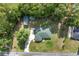 Overhead view of a home with a green roof, complemented by a winding driveway and verdant lawns at 12681 Se 54Th Ave, Belleview, FL 34420