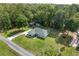 Aerial view of a lovely home featuring an expansive green lawn and surrounding lush trees at 12681 Se 54Th Ave, Belleview, FL 34420