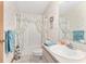 Bathroom with floral-themed shower curtain, neutral vanity and white ceramic sink at 12681 Se 54Th Ave, Belleview, FL 34420