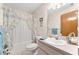Bathroom with floral-themed shower curtain, neutral vanity and white ceramic sink at 12681 Se 54Th Ave, Belleview, FL 34420