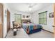 Bedroom with a ceiling fan, two windows, double closets, and a rocking chair at 12681 Se 54Th Ave, Belleview, FL 34420