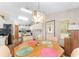 Cozy dining area adjacent to the kitchen, featuring a decorative chandelier and hardwood floors at 12681 Se 54Th Ave, Belleview, FL 34420