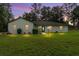 Inviting home at twilight with a lush lawn, landscape lighting, and flowering shrubs enhancing the curb appeal at 12681 Se 54Th Ave, Belleview, FL 34420