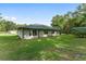 Exterior view of the home showcasing a spacious yard with mature trees, and a green roof at 12681 Se 54Th Ave, Belleview, FL 34420