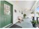 Inviting front porch with green door, welcome wreath, and a charming wooden bench at 12681 Se 54Th Ave, Belleview, FL 34420
