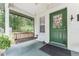 Cozy front porch featuring a swing and green front door with decorative details at 12681 Se 54Th Ave, Belleview, FL 34420