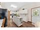 Bright kitchen featuring white cabinets, central island, and modern appliances, with wood flooring throughout at 12681 Se 54Th Ave, Belleview, FL 34420