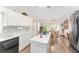Modern kitchen with white cabinets and countertops, black appliances, and adjacent dining area at 12681 Se 54Th Ave, Belleview, FL 34420