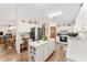 Kitchen with white cabinets, center island, stainless steel refrigerator, and adjacent dining area at 12681 Se 54Th Ave, Belleview, FL 34420