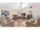 Spacious living room with vaulted ceiling, plush seating, fireplace, and hardwood floors at 12681 Se 54Th Ave, Belleview, FL 34420