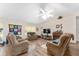 Bright living room featuring ceiling fan, vaulted ceiling, fireplace, hardwood floors and comfortable furniture at 12681 Se 54Th Ave, Belleview, FL 34420