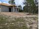 Angled side view of unfinished concrete block home in undeveloped neighborhood at 13322 Sw 85 Cir, Ocala, FL 34473