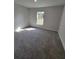 Sun-filled bedroom features neutral walls, plush carpeting, and large window with natural light at 13585 Sw 51St Ln, Ocala, FL 34481