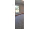 Bedroom with neutral walls and carpet features a window offering views of a lush green yard at 13585 Sw 51St Ln, Ocala, FL 34481