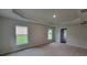 Main bedroom with tray ceiling, carpet floors, and natural light at 13585 Sw 51St Ln, Ocala, FL 34481