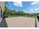 Expansive back deck with black metal railing offers a view of the large, treed backyard at 13741 Sw 73Rd St, Ocala, FL 34481