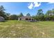 View of the home's exterior showcasing the spacious deck and expansive, grassy backyard at 13741 Sw 73Rd St, Ocala, FL 34481