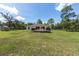 A backyard featuring a large deck area, surrounded by lush greenery and a fenced perimeter at 13741 Sw 73Rd St, Ocala, FL 34481