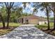 Inviting single-story home with a long driveway, neat landscaping, and mature trees at 13741 Sw 73Rd St, Ocala, FL 34481