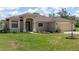 Charming single-story home with manicured lawn and an arched entryway to a blue-trimmed front door at 13741 Sw 73Rd St, Ocala, FL 34481