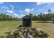 Durable shed stands out in the spacious backyard, enhanced by blue skies and scattered clouds at 13741 Sw 73Rd St, Ocala, FL 34481