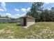 Well-maintained shed in a fenced-in grassy backyard with a blue sky backdrop at 13741 Sw 73Rd St, Ocala, FL 34481