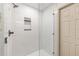 Modern shower featuring white subway tile, sleek hardware, a niche, and glass door at 13741 Sw 73Rd St, Ocala, FL 34481