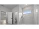 Modern bathroom featuring a walk-in shower with marble tile, a bright window, and a view to another room at 13780 Sw 42Nd Court Rd, Ocala, FL 34473