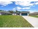 Charming one-story home featuring a well-maintained lawn, blue garage door, and modern gray exterior at 13780 Sw 42Nd Court Rd, Ocala, FL 34473