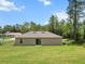Rear exterior view of a home with a sliding glass door leading to the backyard at 15138 Sw 50Th Avenue Rd, Ocala, FL 34473