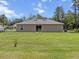 Backyard featuring a large grassy area, a sliding glass door, and an AC unit at 15138 Sw 50Th Avenue Rd, Ocala, FL 34473