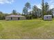 Backyard featuring a large grassy area, a small storage shed, and a clear blue sky at 15138 Sw 50Th Avenue Rd, Ocala, FL 34473