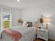 Cozy bedroom with a decorative lamp on nightstand, window with view, and queen sized bed at 15138 Sw 50Th Avenue Rd, Ocala, FL 34473
