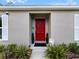 Close-up of the home's entrance featuring a vibrant red door and manicured landscaping at 15138 Sw 50Th Avenue Rd, Ocala, FL 34473