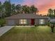 Charming single-story home featuring a well-manicured lawn and a classic red front door at 15138 Sw 50Th Avenue Rd, Ocala, FL 34473