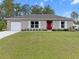 Charming single-story home with a well-maintained lawn and a red front door at 15138 Sw 50Th Avenue Rd, Ocala, FL 34473