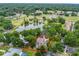 Beautiful aerial view of a private home, surrounded by mature trees, overlooking a peaceful pond and recreation area at 1630 Se 29Th Ter, Ocala, FL 34471