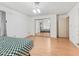 Bright bedroom with laminate flooring, a closet with mirrored doors, and white trim at 1630 Se 29Th Ter, Ocala, FL 34471
