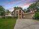 Elegant two-story home featuring dual balconies, a patterned concrete driveway, and lush landscaping at 1630 Se 29Th Ter, Ocala, FL 34471