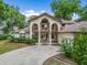 Elegant two-story home featuring dual balconies, a patterned concrete driveway, and lush landscaping in a desirable neighborhood at 1630 Se 29Th Ter, Ocala, FL 34471