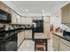 Kitchen with tile floors, wood cabinets, black counters, and stainless steel appliances at 1630 Se 29Th Ter, Ocala, FL 34471